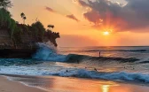 surfers catching perfect waves at sunset on a pristine beach in bali.